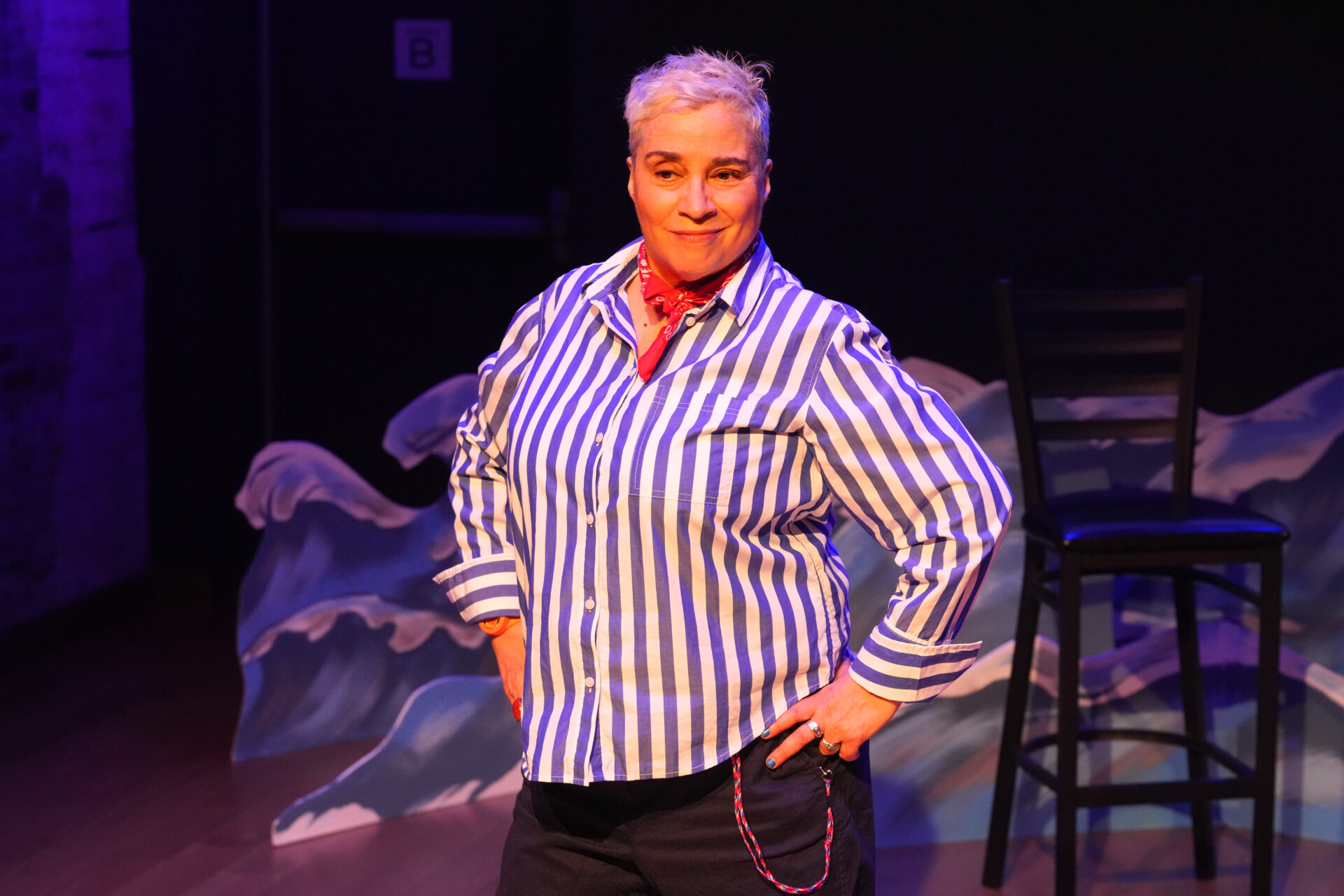 Marga Gomez in striped shirt in front of waves